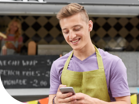 young person smiling and looking at phone